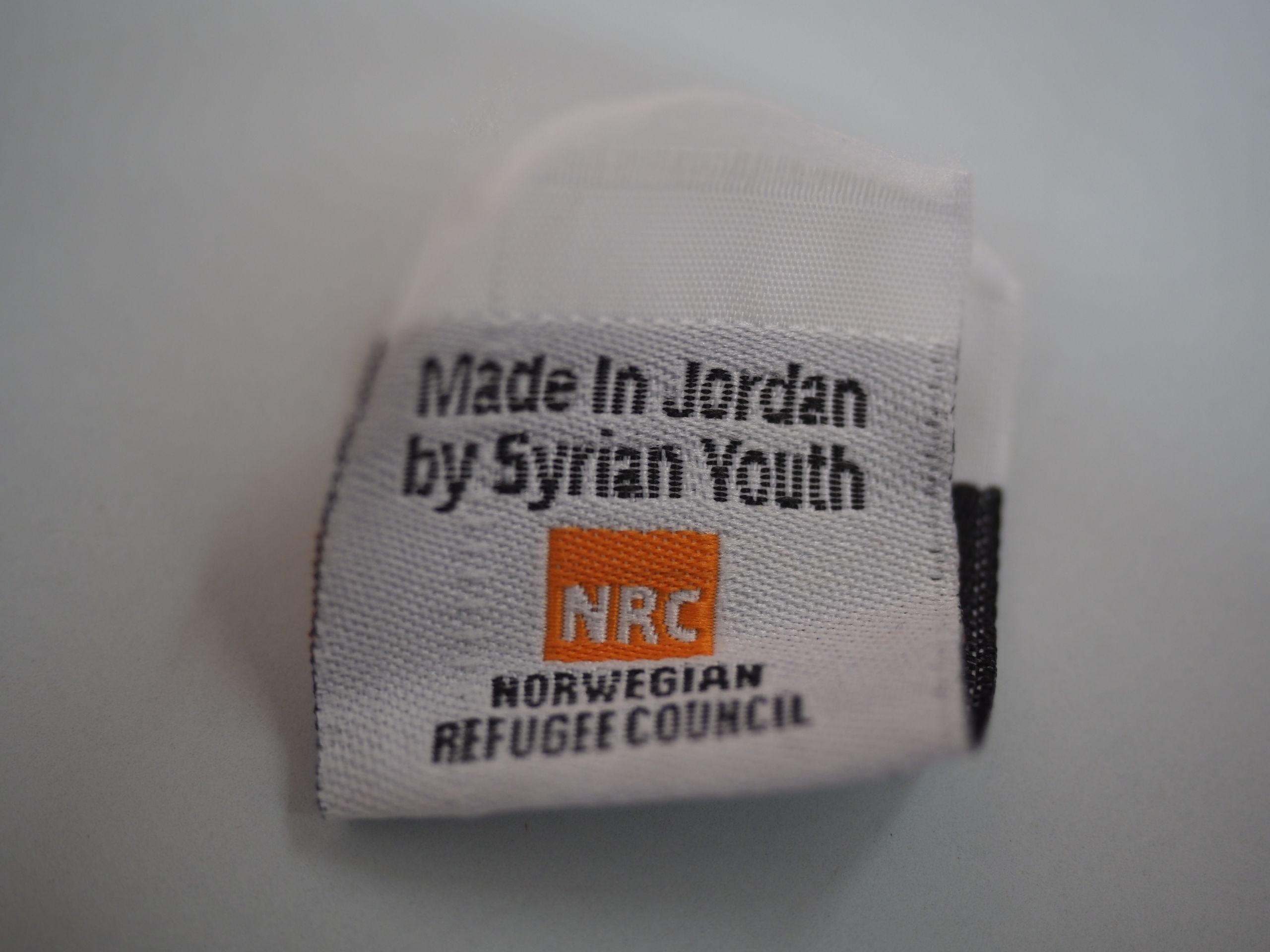 En merkelapp til klesplagg sydd på skredderkurset: "Made in Jordan by Syrian youth"