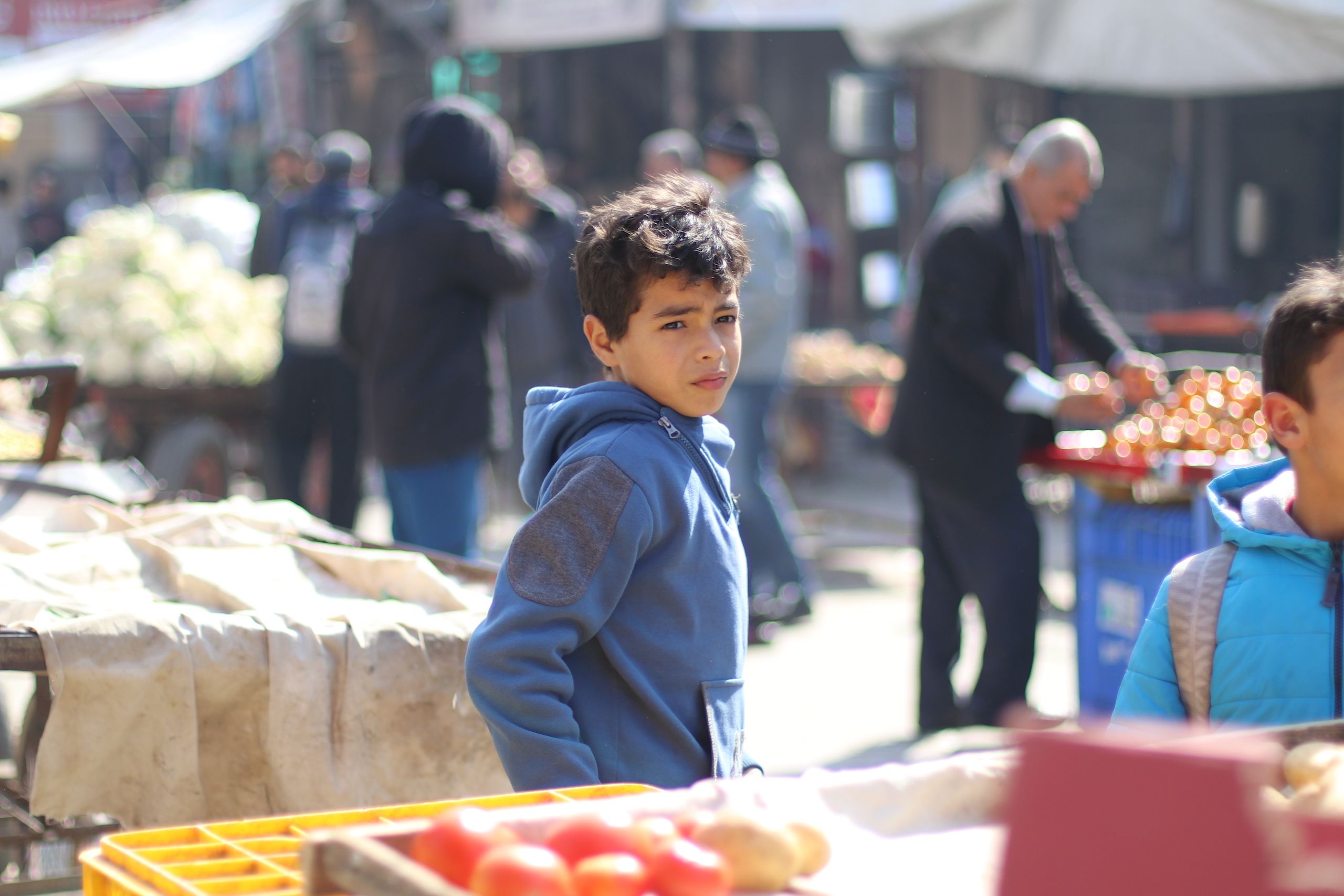 A boy in an outdoor food market.