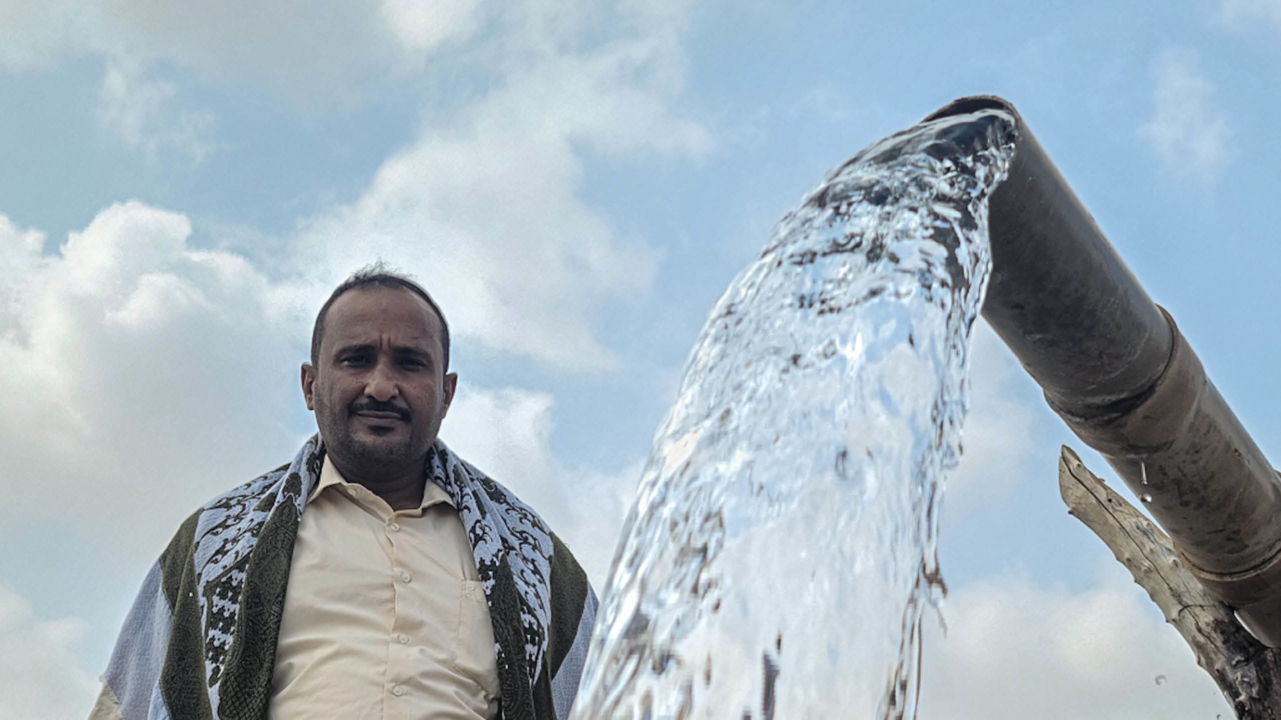 Yousif Agili vid en renoverade vattenkälla