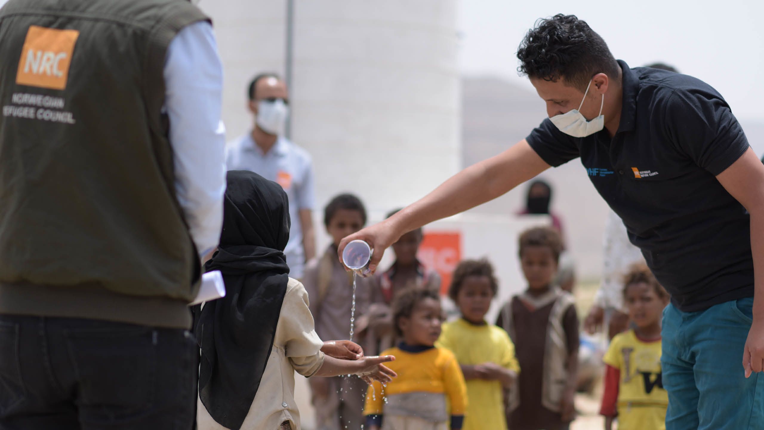 NRC Flyktinghjälpens medarbetare demonstrerar hur man tvättar händerna.