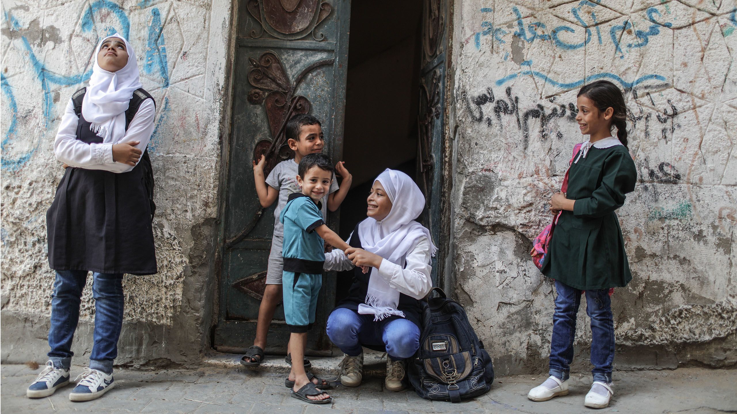 Five Palestinian siblings, three girls and two boys, outside their family home. 