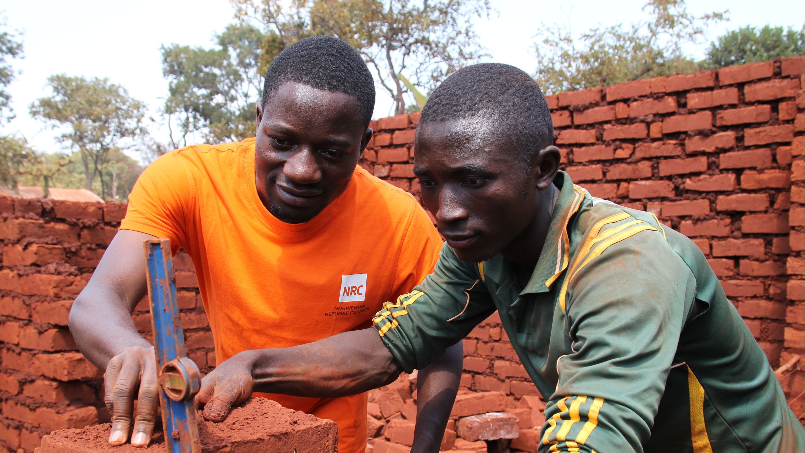 An NRC’s shelter officer is providing training to a young man.
