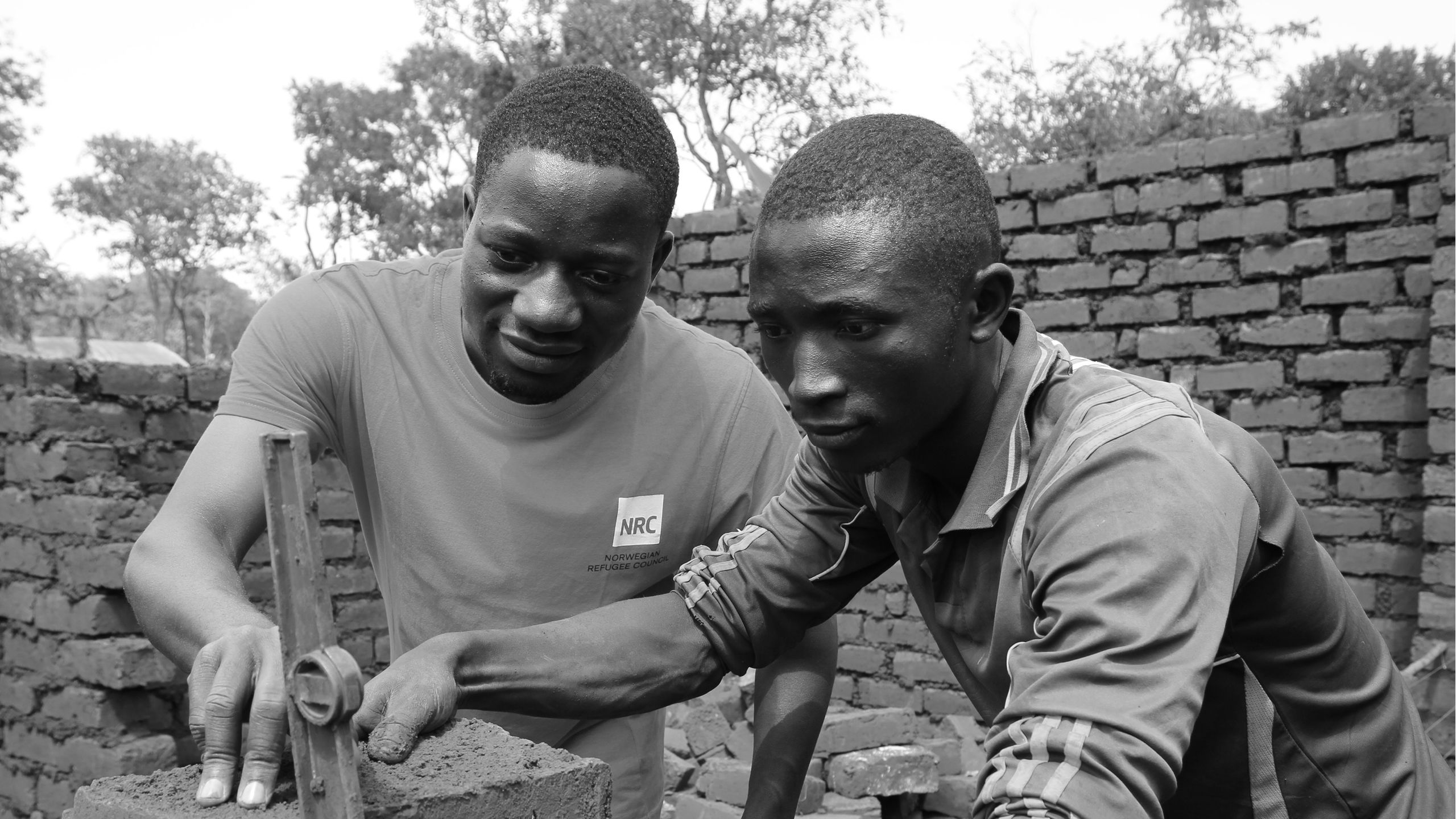 An NRC’s shelter officer is providing training to a young man.